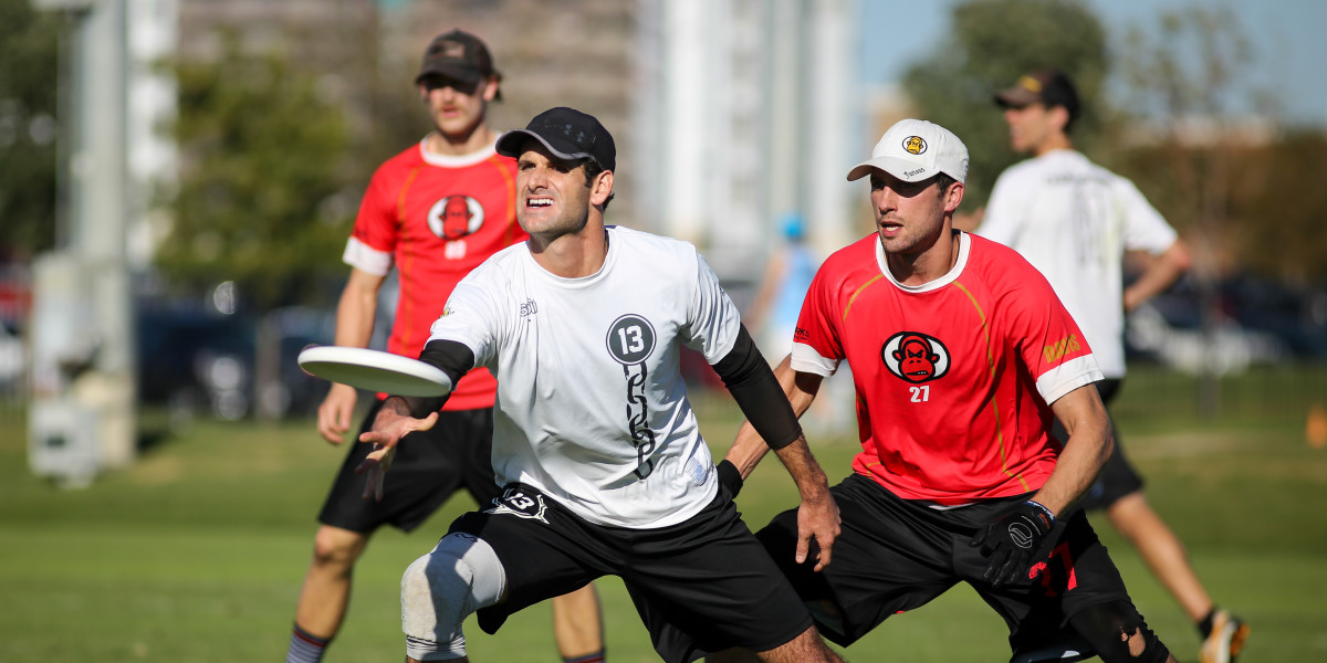 Jared Inselmann of Chain Lightning makes a throw while marked by Alex Davis of Furious George during pool play at the 2014 USA Ultimate National Championships. Photo by Christina Schmidt, UltiPhotos.com.