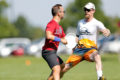 Two ultimate frisbee players competing for the disc during a game.
